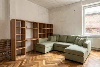 Salon modulable avec canapé sectionnel et bureau intégré dans un appartement urbain au parquet en chêne
